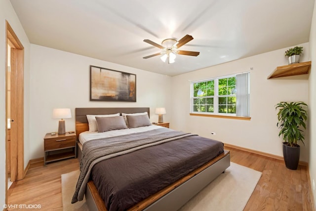 bedroom with baseboards, light wood finished floors, and ceiling fan