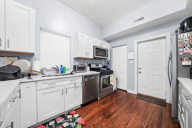 934 N Noble St, Chicago, IL 60642 - kitchen with stainless steel appliances, a sink, dark wood-style flooring, light countertops, and white cabinetry