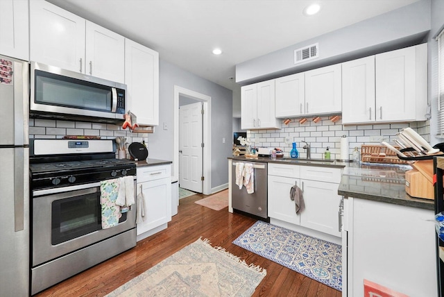 934 N Noble St, Chicago, IL 60642 - kitchen with stainless steel appliances, a sink, dark countertops, backsplash, and recessed lighting