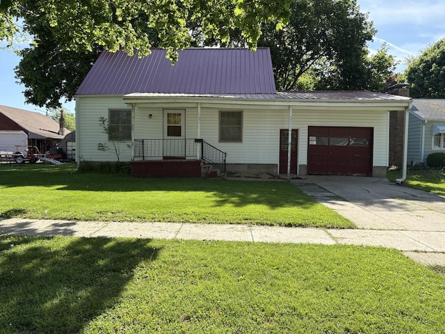 953 11th St N, Rochelle, IL 60168 - view of front facade featuring an attached garage, a front yard, concrete driveway, and metal roof