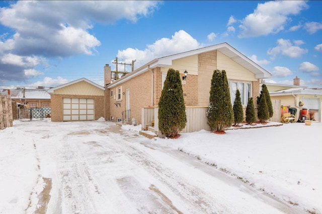 126 Strieff Ave, Chicago Heights, IL 60411 - view of snow covered exterior featuring brick siding, a garage, and a chimney