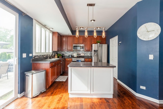 554 Truman Dr, Oswego, IL 60543 - kitchen with appliances with stainless steel finishes, wood finished floors, decorative backsplash, baseboards, and a sink