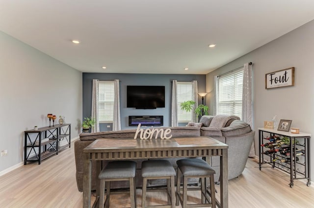 living room with light wood-style floors, baseboards, and recessed lighting