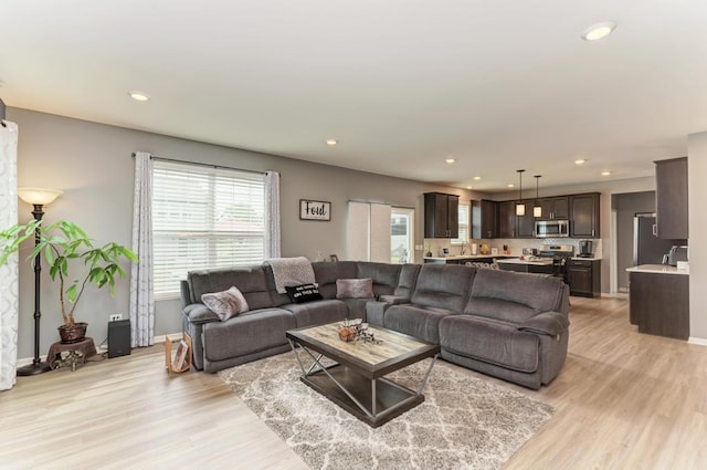 living area featuring light wood-style flooring, recessed lighting, and baseboards