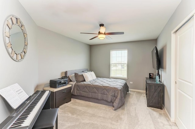 bedroom with light colored carpet, baseboards, and ceiling fan