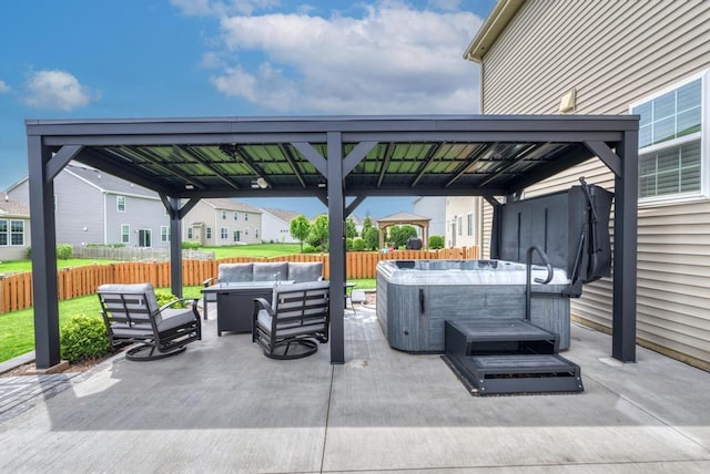 view of patio / terrace with a hot tub, a gazebo, an outdoor hangout area, and fence