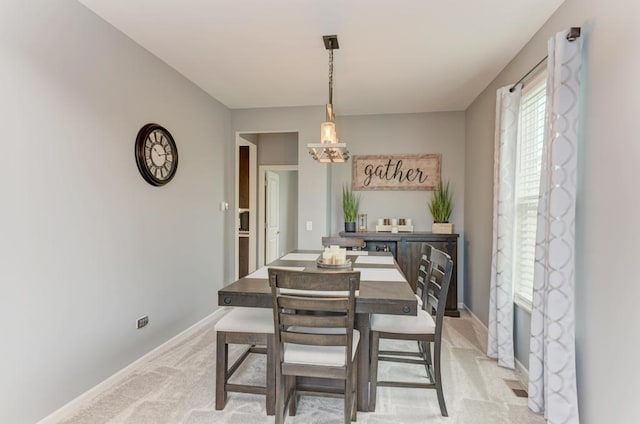dining area featuring light colored carpet and baseboards