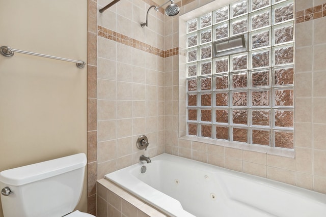 bathroom with toilet and a combined bath / shower with jetted tub