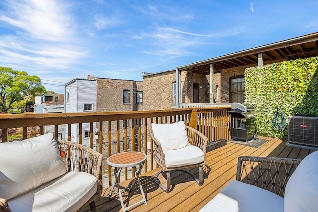 wooden deck featuring central AC unit and area for grilling