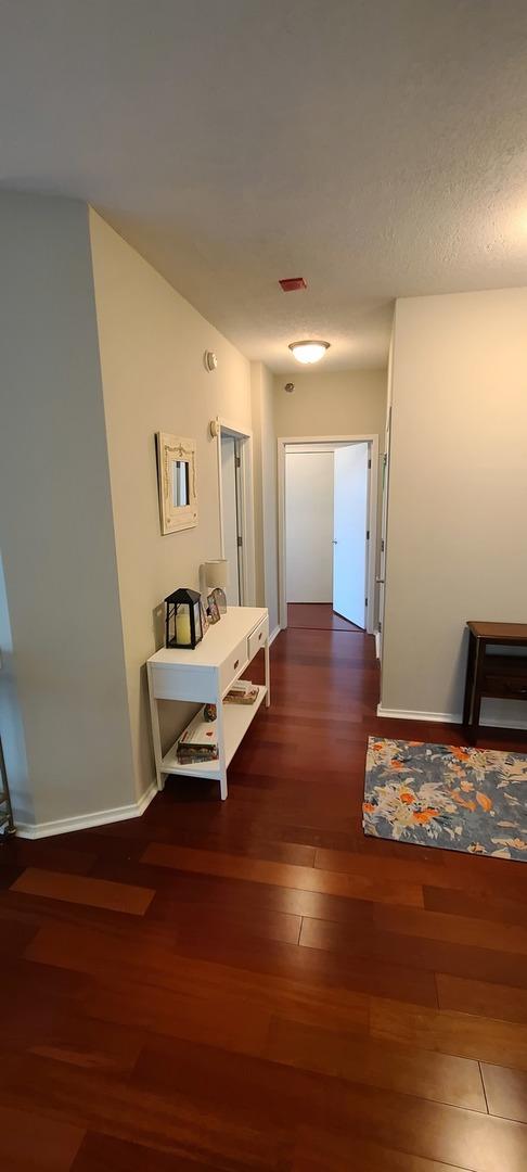 hallway with wood finished floors and baseboards