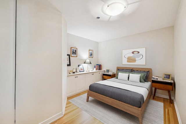 bedroom with light wood-style floors and baseboards