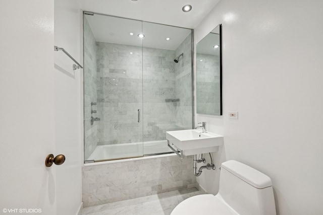 bathroom with toilet, tiled shower / bath, recessed lighting, and a sink