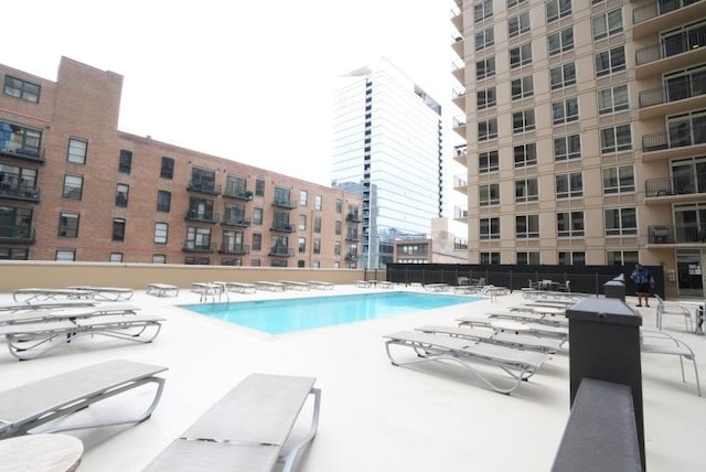 community pool featuring fence and a patio