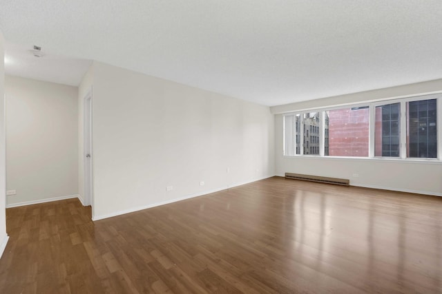 801 S Plymouth Ct Unit 711, Chicago, IL 60605 - spare room featuring wood finished floors, baseboard heating, and baseboards