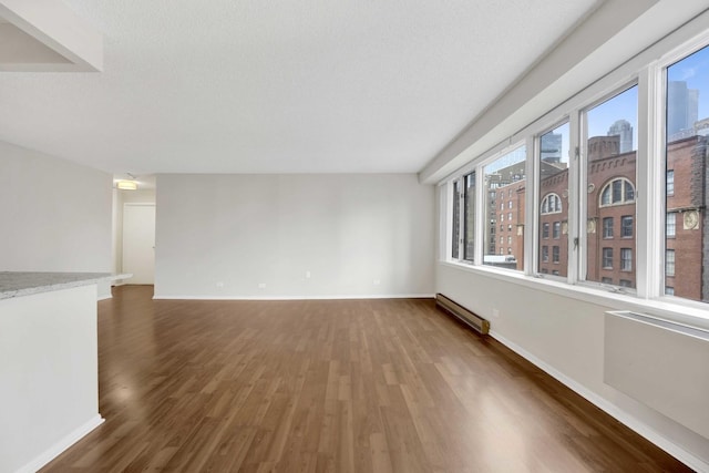 801 S Plymouth Ct Unit 711, Chicago, IL 60605 - empty room with baseboard heating, wood finished floors, baseboards, and a view of city