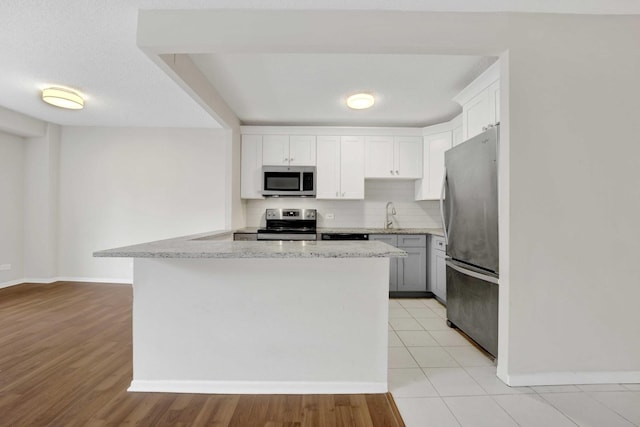 801 S Plymouth Ct Unit 711, Chicago, IL 60605 - kitchen featuring appliances with stainless steel finishes, baseboards, white cabinets, a sink, and decorative backsplash