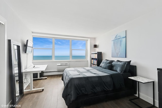 bedroom featuring a baseboard radiator and wood finished floors