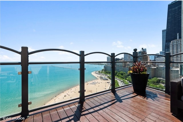 balcony with a view of city and view of water and beach
