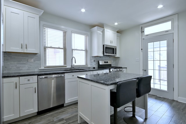 6211 W School St, Chicago, IL 60634 - kitchen featuring stainless steel appliances, a sink, a center island, backsplash, and white cabinets