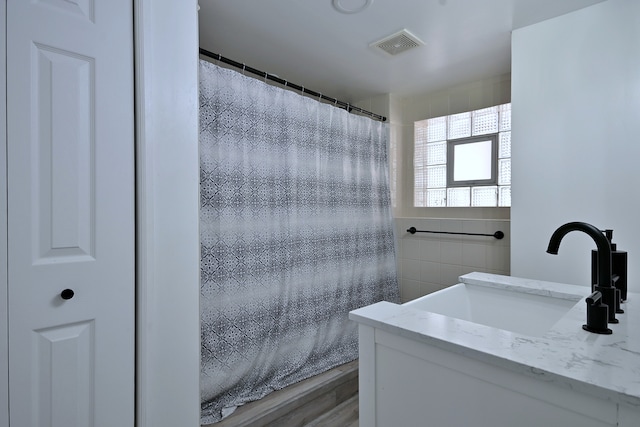 6211 W School St, Chicago, IL 60634 - full bath with tile walls, a shower with shower curtain, vanity, and wood finished floors