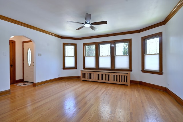 6211 W School St, Chicago, IL 60634 - spare room featuring radiator, arched walkways, ceiling fan, plenty of natural light, and crown molding