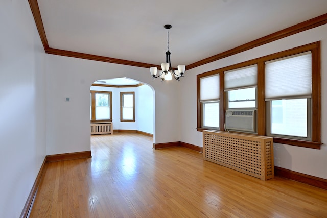 6211 W School St, Chicago, IL 60634 - empty room featuring arched walkways, radiator heating unit, crown molding, and light wood-type flooring