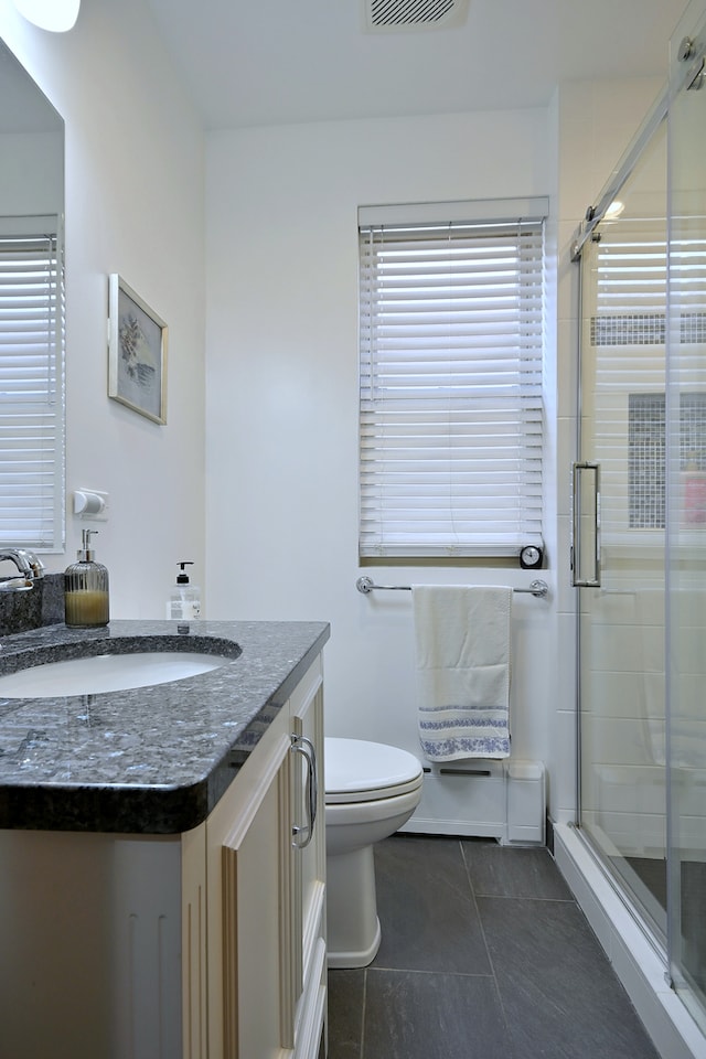 6211 W School St, Chicago, IL 60634 - bathroom with a stall shower, vanity, tile patterned flooring, and toilet