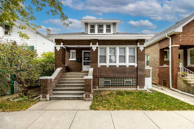 view of front facade with covered porch and brick siding