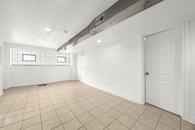 empty room with recessed lighting, baseboards, and light tile patterned floors