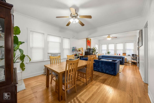 dining space with a ceiling fan, light wood finished floors, crown molding, and baseboards