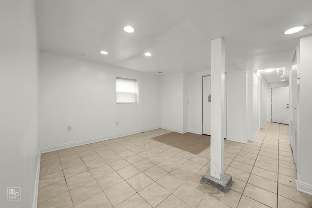 below grade area with recessed lighting, light tile patterned floors, and baseboards