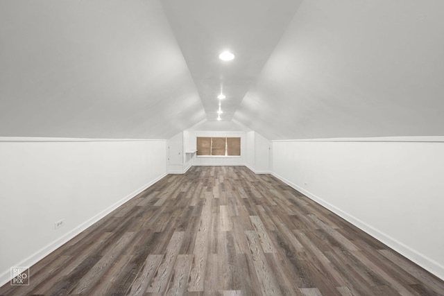 additional living space with baseboards, lofted ceiling, wood finished floors, and recessed lighting