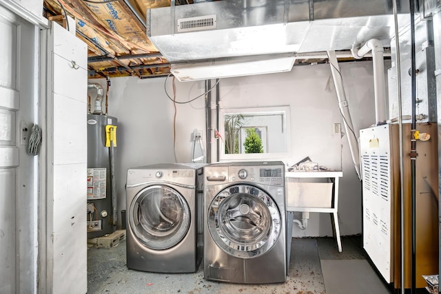 laundry area featuring gas water heater and washing machine and clothes dryer