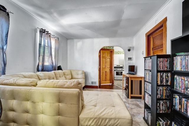 living area featuring ornamental molding and arched walkways