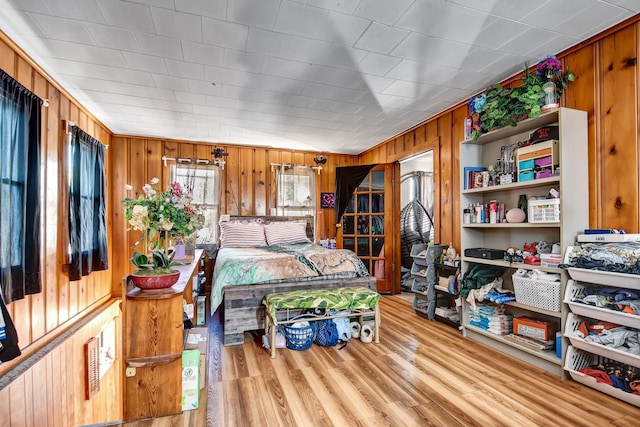 bedroom with wood walls and wood finished floors