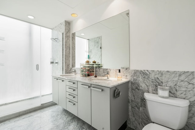bathroom featuring marble finish floors, tile walls, a stall shower, toilet, and double vanity