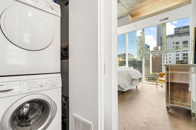clothes washing area featuring estacked washer and dryer and a view of city