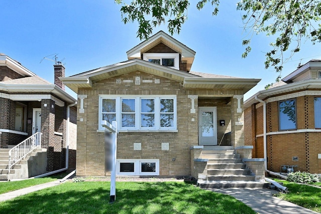 view of front of home featuring brick siding and a front yard