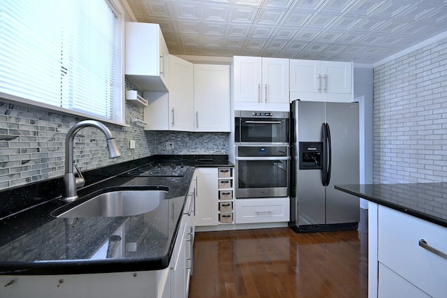 kitchen featuring appliances with stainless steel finishes, a sink, an ornate ceiling, dark wood-style flooring, and white cabinets