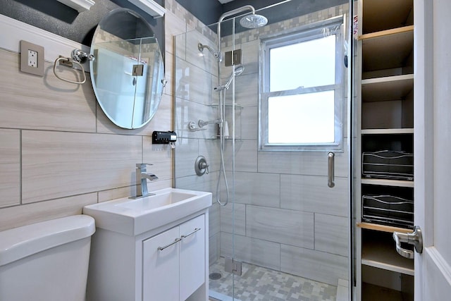 bathroom featuring a shower stall, toilet, and vanity
