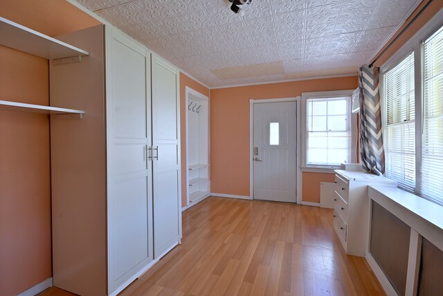 entryway featuring an ornate ceiling, light wood-style flooring, and baseboards