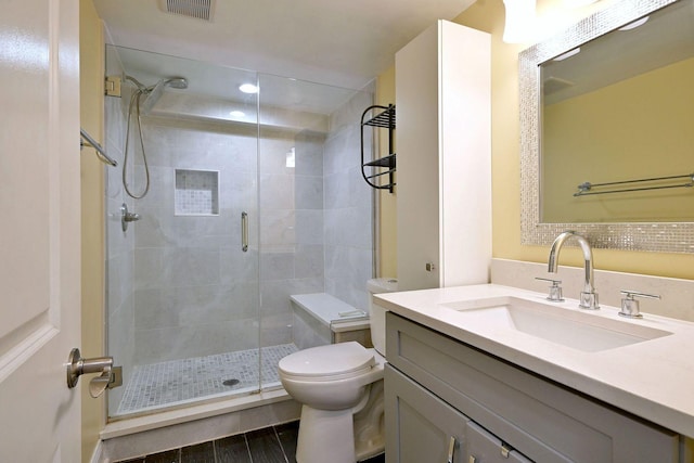 full bathroom featuring a shower stall, toilet, and vanity
