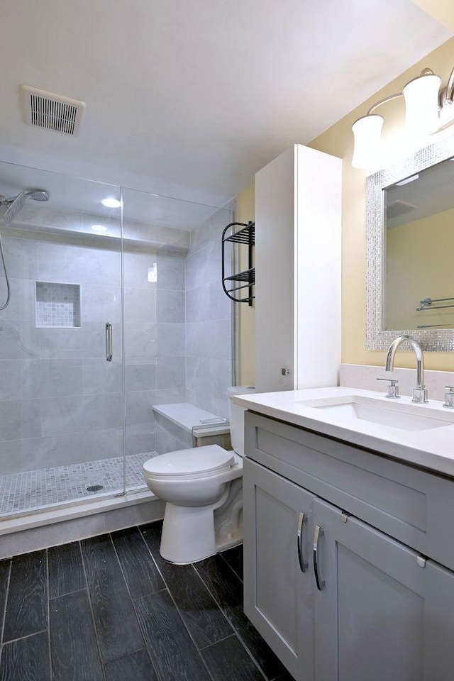 full bathroom with toilet, a shower stall, and vanity