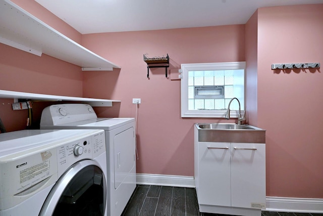 clothes washing area featuring washing machine and clothes dryer, a sink, baseboards, and dark wood-style flooring