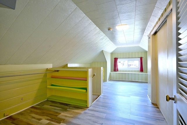bonus room with wood finished floors and vaulted ceiling