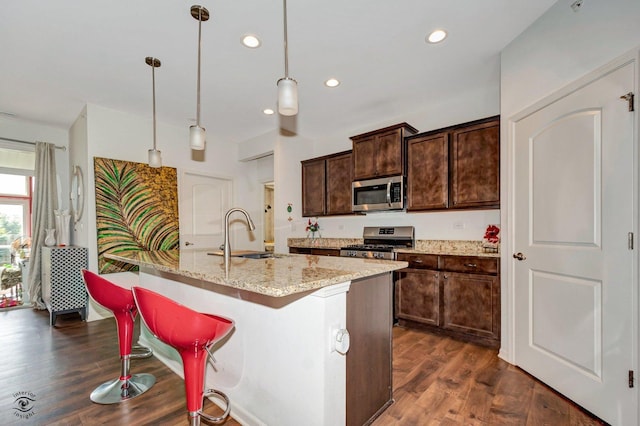 6359 Doral Dr, Gurnee, IL 60031 - kitchen with stainless steel appliances, a sink, dark brown cabinets, light stone countertops, and an island with sink
