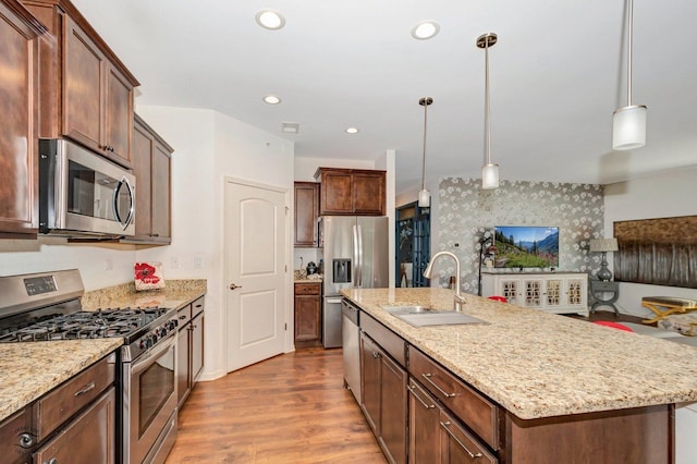 6359 Doral Dr, Gurnee, IL 60031 - kitchen featuring stainless steel appliances, a sink, an island with sink, wood finished floors, and light stone countertops