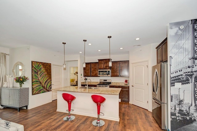 6359 Doral Dr, Gurnee, IL 60031 - kitchen featuring appliances with stainless steel finishes, a sink, dark wood finished floors, dark brown cabinets, and a center island with sink
