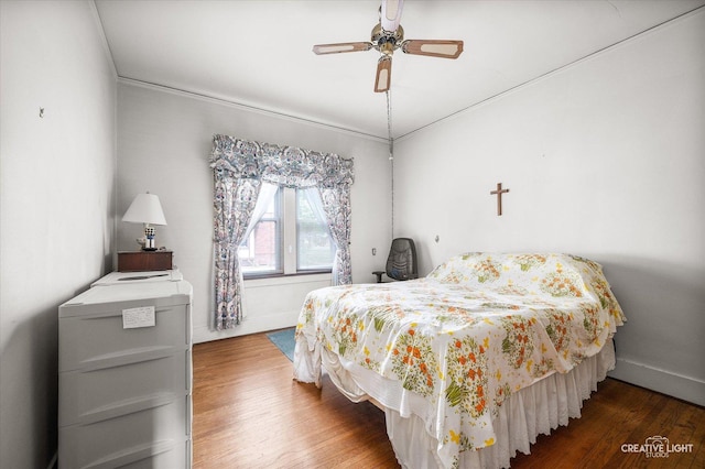 bedroom featuring wood finished floors, baseboards, and a ceiling fan