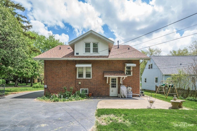 back of house featuring brick siding, a patio, and a shingled roof